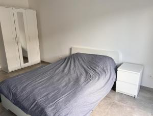 a bedroom with a bed with a gray blanket at Le Franchet in Dinant