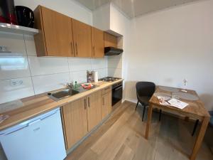 a kitchen with a sink and a wooden table with a tableablish at Meeresbrise in Norden