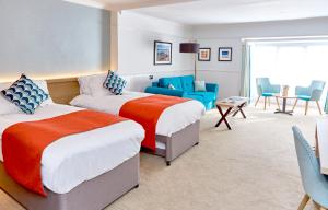 a hotel room with two beds and a couch at Trearddur Bay Hotel in Trearddur