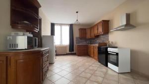 a kitchen with a black and white stove top oven at Grenouilles et coquillages in Saint-Hilaire-Petitville