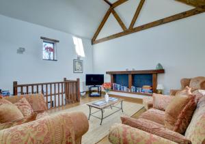 a living room with two couches and a tv at Bramble Cottage in Barbrook