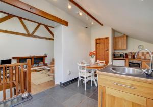 a kitchen with a sink and a table in a room at Bramble Cottage in Barbrook