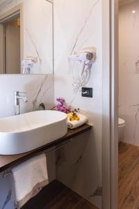 W łazience znajduje się umywalka i lustro. w obiekcie CASCINA SANT'ANTONIO w Albie