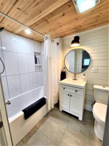 a bathroom with a tub and a sink and a toilet at Beachside-HotTub-Fireplace-Authentically Northern in Traverse City
