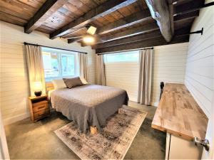 a bedroom with a bed and a large window at Beachside-HotTub-Fireplace-Authentically Northern in Traverse City