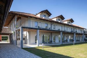 a building with a balcony and a grass yard at CASCINA SANT'ANTONIO in Alba
