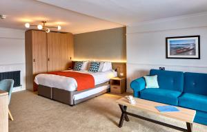 a hotel room with a bed and a couch at Trearddur Bay Hotel in Trearddur