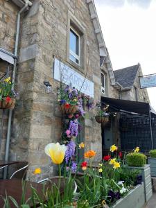 un edificio con flores a un lado. en Garden Rooms Ferry Rd Pitlochry, en Pitlochry