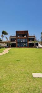 a large building with a grass field in front of it at Casa Pordosol in Fortim