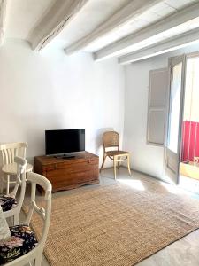 sala de estar con TV de pantalla plana y sillas en Cal Torrentó Apartaments, en Balaguer