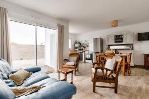 ein Wohnzimmer mit einem blauen Sofa und einer Küche in der Unterkunft Detente et evasion aux Sables dOlonnes in Les Sables-dʼOlonne