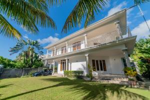 a large white house with a yard at Tropicana Villa in Le Morne