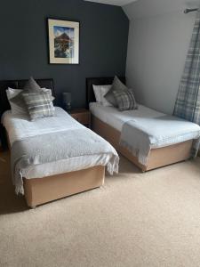 two beds sitting next to each other in a bedroom at Garden Rooms Ferry Rd Pitlochry in Pitlochry