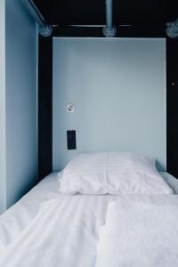 a white bed in a room with a large window at Copenhagen Downtown Hostel in Copenhagen