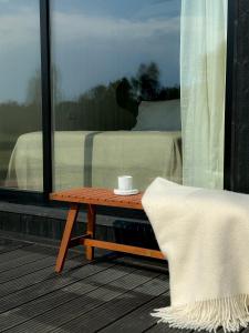 a coffee table on a balcony with a bed at Ragnar Glamp Pitrags Lux PREMIUM in Pitragutsiyeme