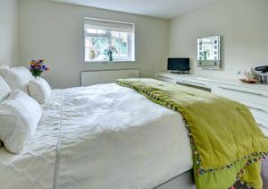 a large white bed with a green blanket on it at Cedars Lodge in Northam
