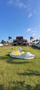 a large kite laying on the grass in a field at Casa Pordosol in Fortim