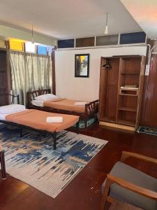 um quarto com três camas e uma mesa e prateleiras em MyDusun Chalet, Taiping, Perak, Malaysia em Taiping