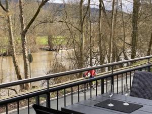 a table on a balcony with a view of a river at Apartment Lahnblick in Marburg an der Lahn