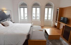 a bedroom with a large bed and a flat screen tv at Internacional Azores Boutique in Horta