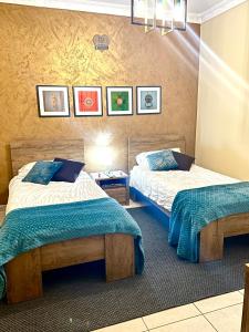- deux lits dans une chambre d'hôtel avec deux couvre-lits dans l'établissement Desert Rose Quiet house 3km away from airport, à Safi