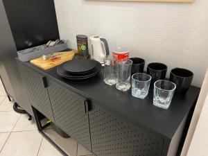 a black table with plates and glasses on it at Central Rooms Apartment in Toruń