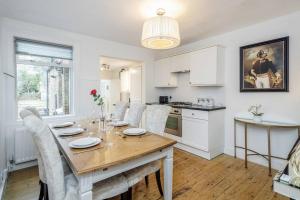 a kitchen and dining room with a table and chairs at Stylish Victorian 3 Bed House Huge Garden/Parking in Staines