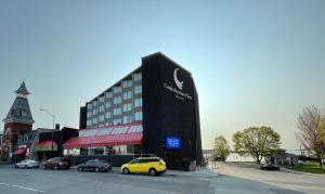 a building with a yellow car parked next to a street at Confederation Place Hotel in Kingston