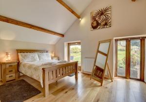 1 dormitorio con 1 cama y suelo de madera en Cider Pound, en Bampton