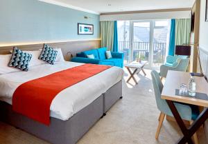トレアルジルにあるTrearddur Bay Hotelのベッド、デスク、椅子が備わるホテルルームです。