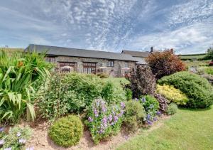 a house with a garden of flowers and plants at Cider Pound in Bampton