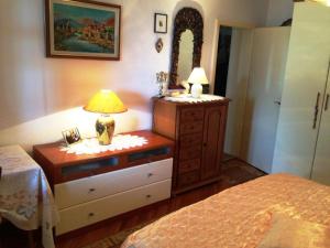 a bedroom with a dresser with a lamp and a mirror at Guest House Ruža in Dubrovnik