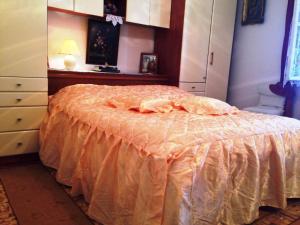a bedroom with a bed with an orange comforter at Guest House Ruža in Dubrovnik