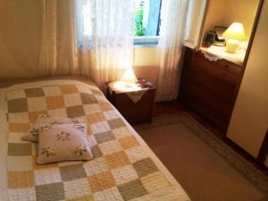 a small bedroom with a bed and a window at Guest House Ruža in Dubrovnik