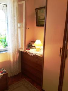 a room with a lamp on a dresser with a window at Guest House Ruža in Dubrovnik