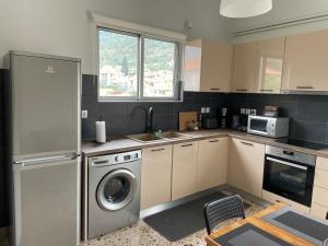 a kitchen with a washer and dryer in it at Happy Home in Leonidio