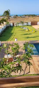 a view of a lawn with trees and a pool at Casa Pordosol in Fortim