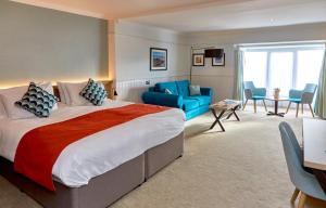 a bedroom with a large bed and a living room at Trearddur Bay Hotel in Trearddur