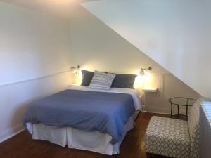 a bedroom with a bed and a chair and lights at La Maison Bellemare in Saint-Jean-des Piles