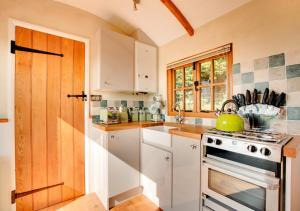 a kitchen with white cabinets and a stove top oven at The Cloud in Bampton