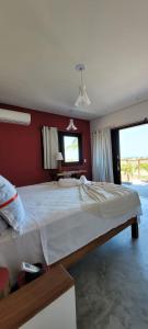 a bedroom with a large bed with a red wall at Casa Pordosol in Fortim