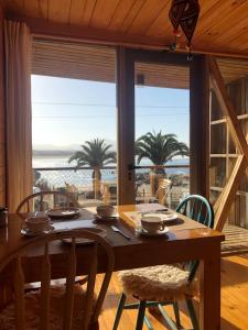 una sala da pranzo con tavolo e vista sull'oceano di La Ritoqueña Hotel de Playa a Concón