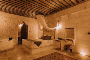 a bedroom with a bed and a sink and a tub at AKRİTİS STONE HOUSE in Urgup