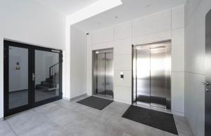 Milo Aparthotel في فروتسواف: ممر فيه مصعدين في مبنى