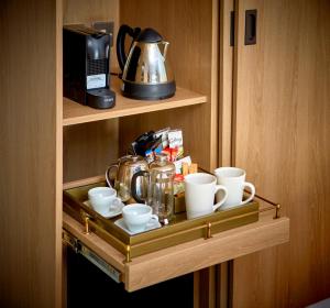 a shelf with cups and a coffee maker on it at Trearddur Bay Hotel in Trearddur