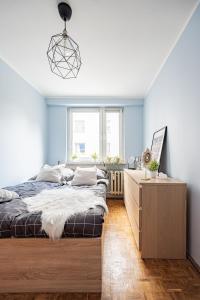 Un dormitorio con una cama y una cómoda de madera. en NiceOne Apartment Number 1 - W samym Centrum!, en Wroclaw