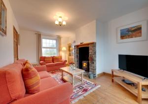 a living room with a couch and a fireplace at Coastguard Cottage in Blagberry