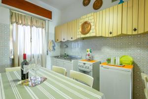 a kitchen with a table with a bottle of wine at La Romana Antica in Madonna di Fornelli