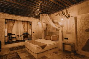 a bedroom with a bed and a table in a room at AKRİTİS STONE HOUSE in Urgup