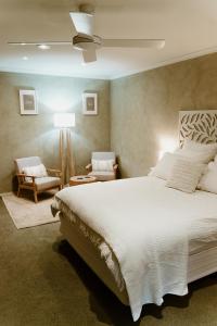 1 dormitorio con 1 cama blanca grande y 1 silla en The Cherry Blossom Suite, en The Patch
